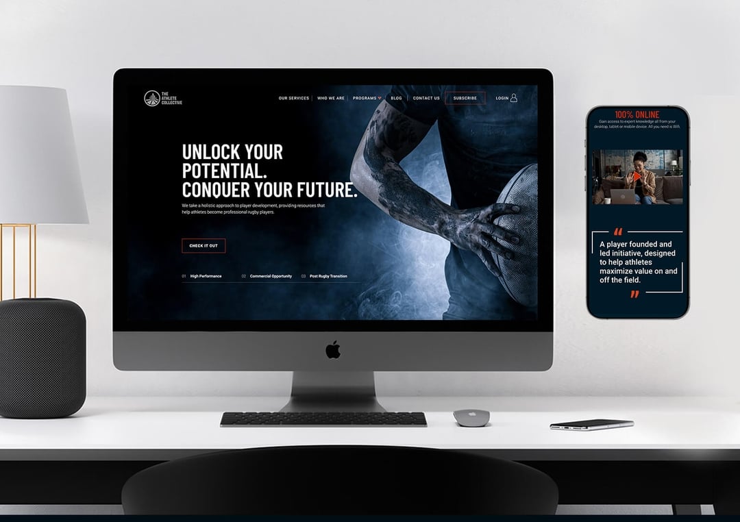 Modern desk setup with an iMac displaying a sports website featuring a tattooed arm holding a rugby ball and bold text 'Unlock Your Potential. Conquer Your Future.', next to a smartphone showing a testimonial on a white wall. athlete collective thumbnail